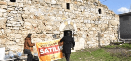 A Turkish realtor attempts to place a "for sale" sign on an Armenian church in Sepastia